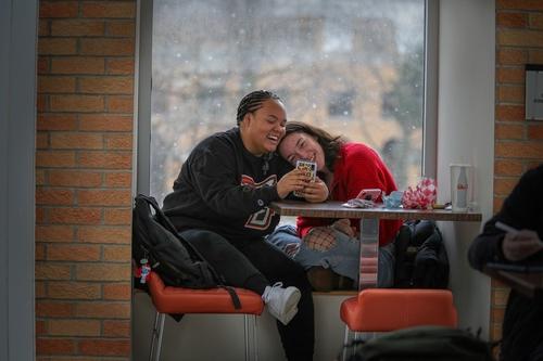 两个学生在午餐时间玩社交媒体