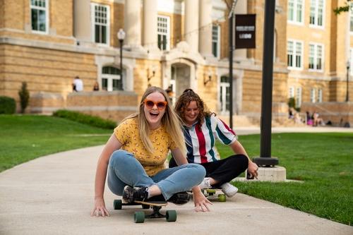 两个学生在外面玩滑板