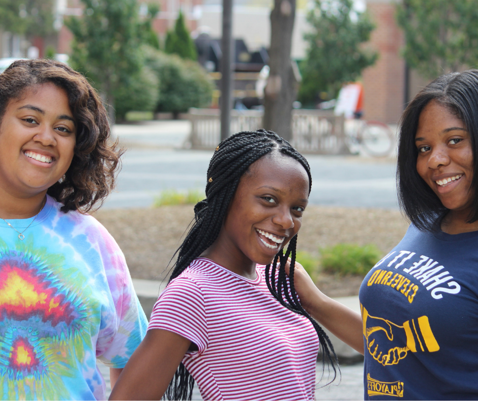 Three female students smiling at the camera