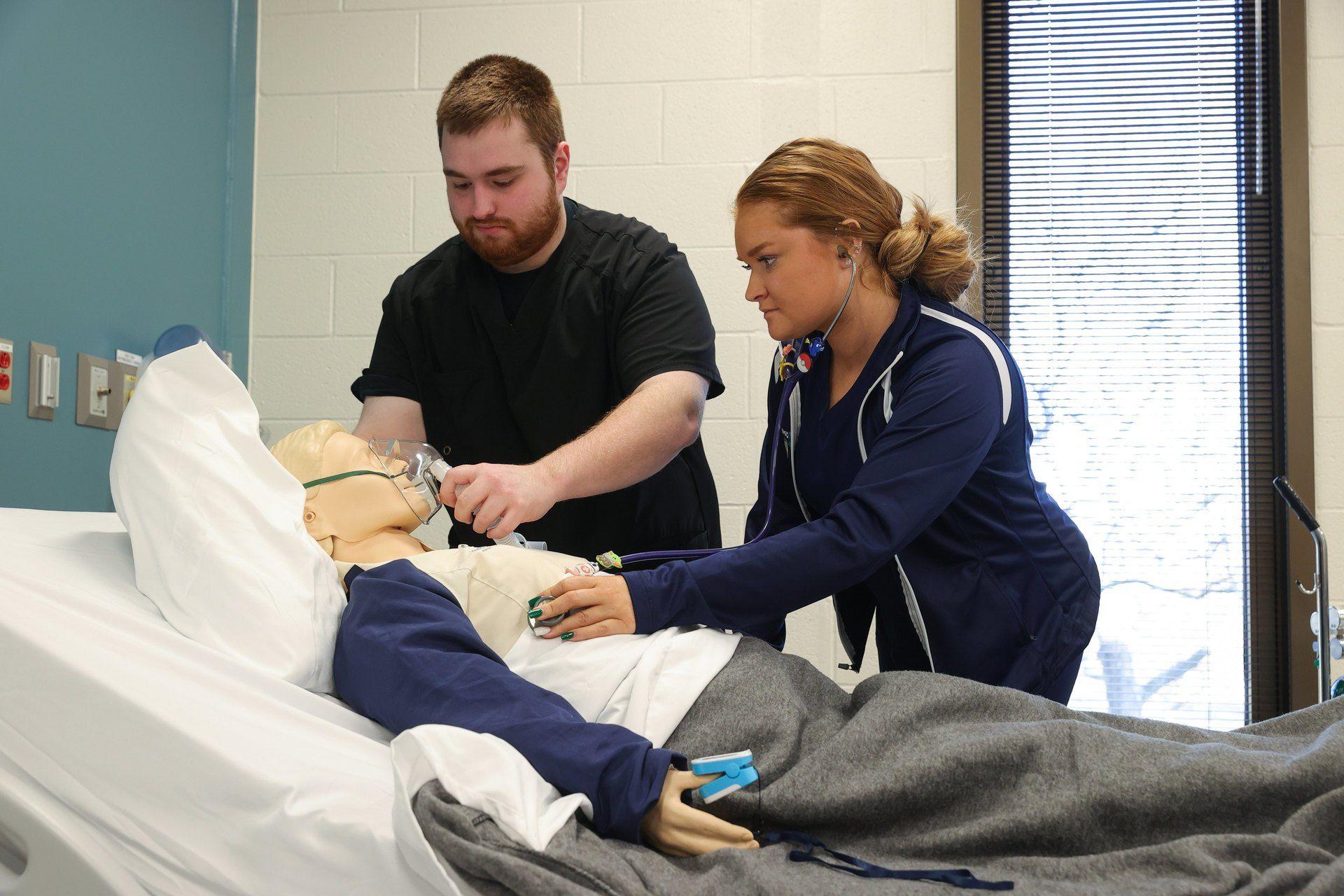 Two students learning to use life support ventilators.